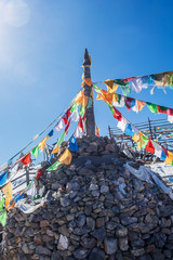 Prayer flags and stupa at the peak of Shika Snow Mountain or Blue Moon Valley, landmark and popular for tourists attractions in Zhongdian city (Shangri-La). Yunnan, China. Asia travel concept