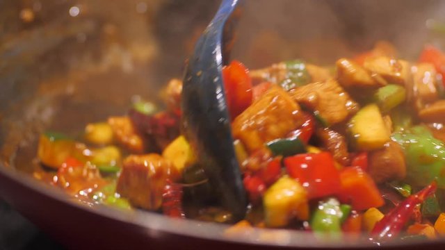 Delicious Asian stir fry cuisine sizzling in a pan. Food is cooking and stirring in slow motion