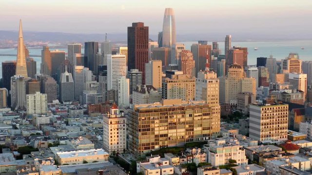 San Francisco city, Aerial, tilt up, drone shot of office buildings and skyscrapers in downtown, during sunrise, in California, United states