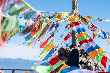 Prayer flags and stupa at the peak of Shika Snow Mountain or Blue Moon Valley, landmark and popular for tourists attractions in Zhongdian city (Shangri-La). Yunnan, China. Asia travel concept