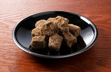 Shooting a block of brown sugar in a plate placed on a Japanese background from an angle