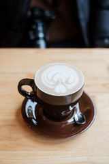 Cup of hot art chocolate coffee on wooden table in cafe shop