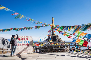 Young woman traveler traveling at Shika Snow Mountain or Blue Moon Valley in Zhongdian city (Shangri-La). Yunnan, China. Chinese character means 4500 meters above sea level