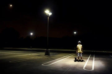 man alone in parking lot at night