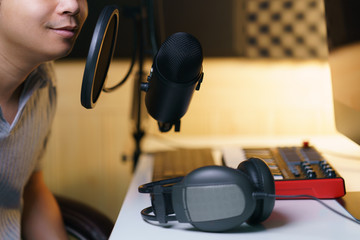 Mand using condenser microphone with earphone and sound mixing console board. Equipment for the...