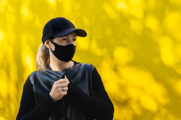 Black mask on the dark background during pandemic infection. Women wear protective face mask against influenza virus. Pandemic coronavirus 2020 and Quarantine. Stop the virus and epidemic diseases