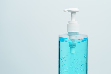 Clear blue hand sanitizer in a clear pump bottle on a white background.