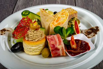 food platter with meat and cheese rolls and vegetables with sauces