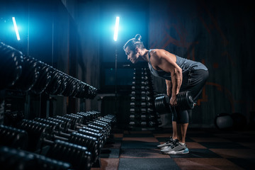 young athlete has physical workout with barbell in modern gym
