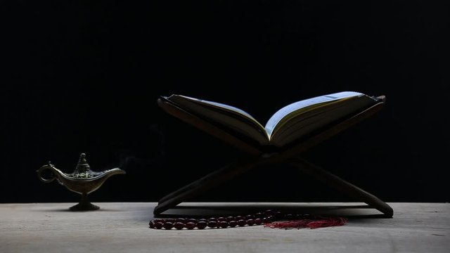 Quran in the mosque - open for prayers The black background of the Muslims around the world placed on a wooden board Quran in the mosque - open for prayers