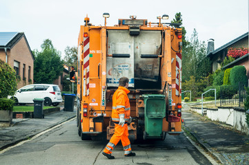 Garbage removal at work - garbage collector picks up the garbage