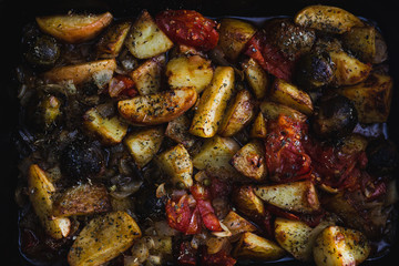 plant-based food, vegan veggie roast with potatoes apples brussel sprouts and tomatoes in oven tray