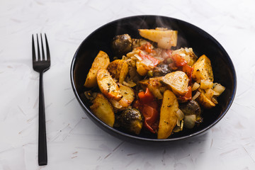 plant-based food, vegan veggie roast with potatoes apples brussel sprouts and tomatoes