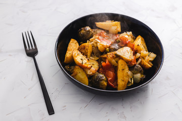 plant-based food, vegan veggie roast with potatoes apples brussel sprouts and tomatoes