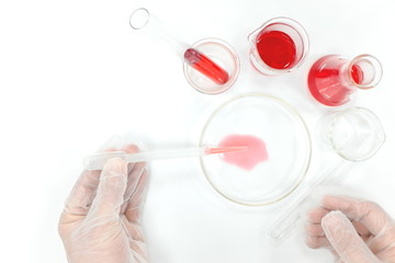 Scientific research laboratory flat lay. Scientist hands working on red liquid chemicals 