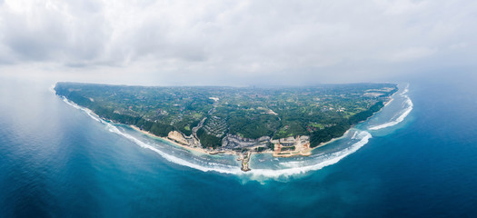 Aerial top view from above to Peninsula Bukit in Bali island, Indonesia. Beautiful panoramic picture in blue colours. Waves and coastline in Indian ocean. Melasti beach location.