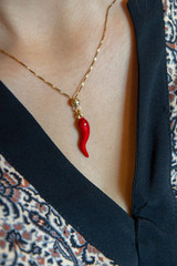 small red horn lucky charm on a girl's neck
