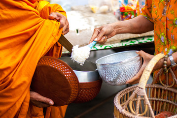 Fototapeta na wymiar Put rice in alms bowl for monks