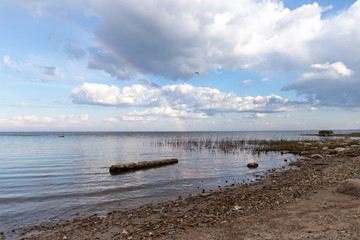 Rainbow over the sea with cloudy skies on a sunny day in spring.