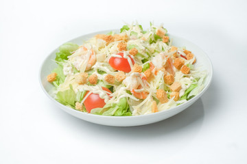 light summer salad in a white plate on a white background
