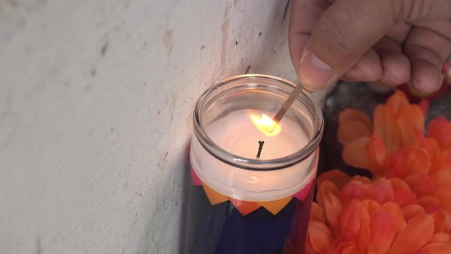 Man Lighting a Day of the Dead Candle with a match while celebrating Dia de los Muertos in Slow Motion