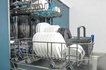 Dishware (plates) inside built-in dishwasher,  . Dishwashing machine rack