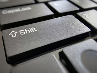 Shift button on computer keyboard with copy space on the right side.  Selective focus on the word...