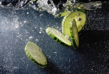 Water drops on ripe cucumber. Fresh vegetables background with copy space for your text. Vegan concept.
