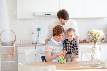 family plays in the kitchen with a child