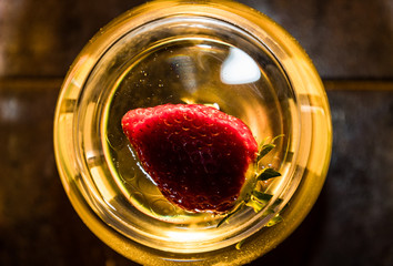Strawberry floating inside a wine glass top view