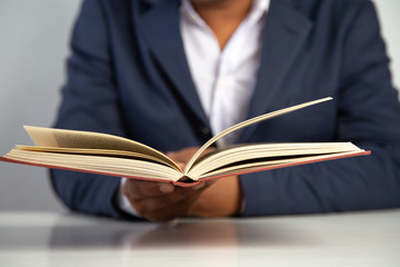 Businessman reading  a book on a desk in the office,