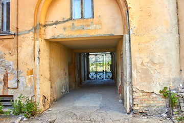 Fototapeta na wymiar Entrance to the yard through narrow street between buildings