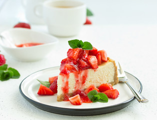 Slice of cheesecake with strawberries, mint and sauce. Selective focus