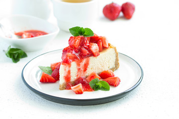 Slice of cheesecake with strawberries, mint and sauce. Selective focus
