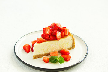 Slice of cheesecake with strawberries, mint and sauce. Selective focus