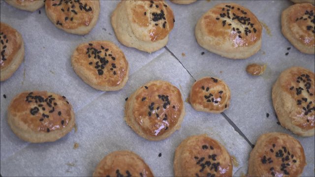Fresh and hot cookies on tray with oven paper.