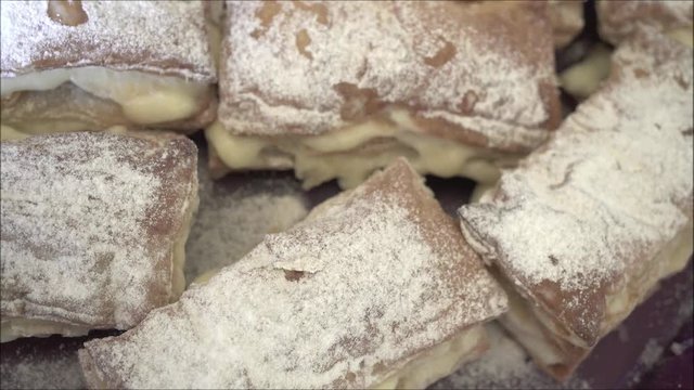 Pastry pies with white sugar powder on tray.