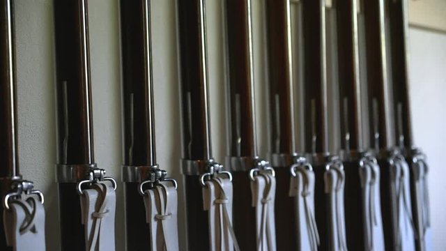 Guns standing straight against the wall. Pan to the right. Muskets.