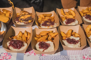 Preparing gourmet burgers or hamburgers with potatoes, bacon, cheese, buns. Detail of  half made burgers in cardboard boxes