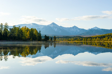 lake, Altai, autumn day. Taiga, beautiful sky, mountains and mountain reflections in the lake.