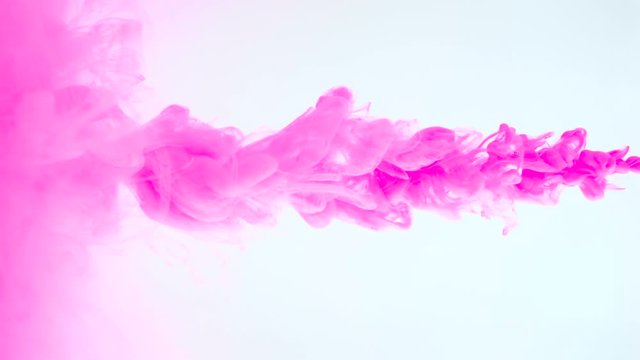 Footage of pink paint flowing in water