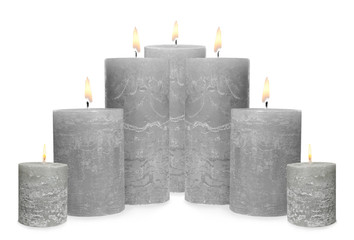 Set of burning grey candles on white background