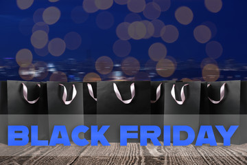 Black Friday. Many shopping bags on wooden surface
