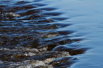 Obraz premium A line of rocks in hard flowing stream in Finnish rapids