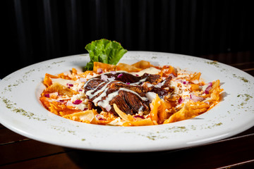 red chilaquiles with beef jerky and hot sauces on the side