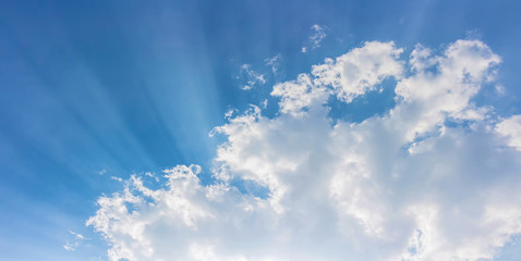 sun rays light in blue sky with bright white clouds