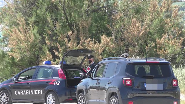 Carabinieri con mascherina controllano automobilisti durante il periodo del corona virus, covid-19