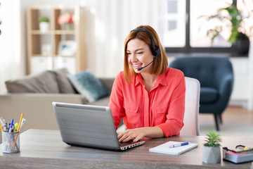 remote job, technology and people concept - happy smiling young woman with headset and laptop...