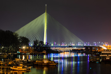 Fototapeta na wymiar Ada Bridge illuminated at night, famous modern Belgrade landmark