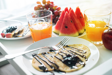 Morning breakfast in bed. White tray orange juice